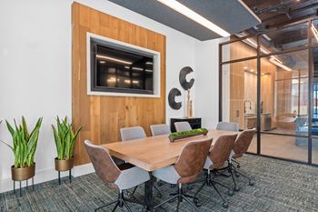 A conference room with a wooden table and chairs.